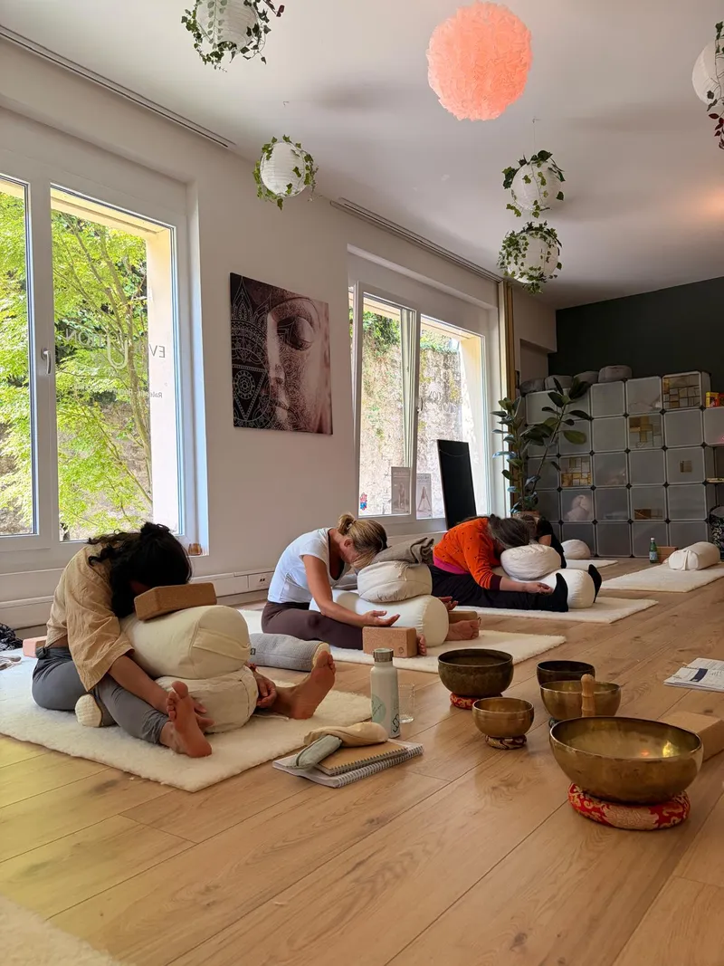 Students in forward fold with singing bowls